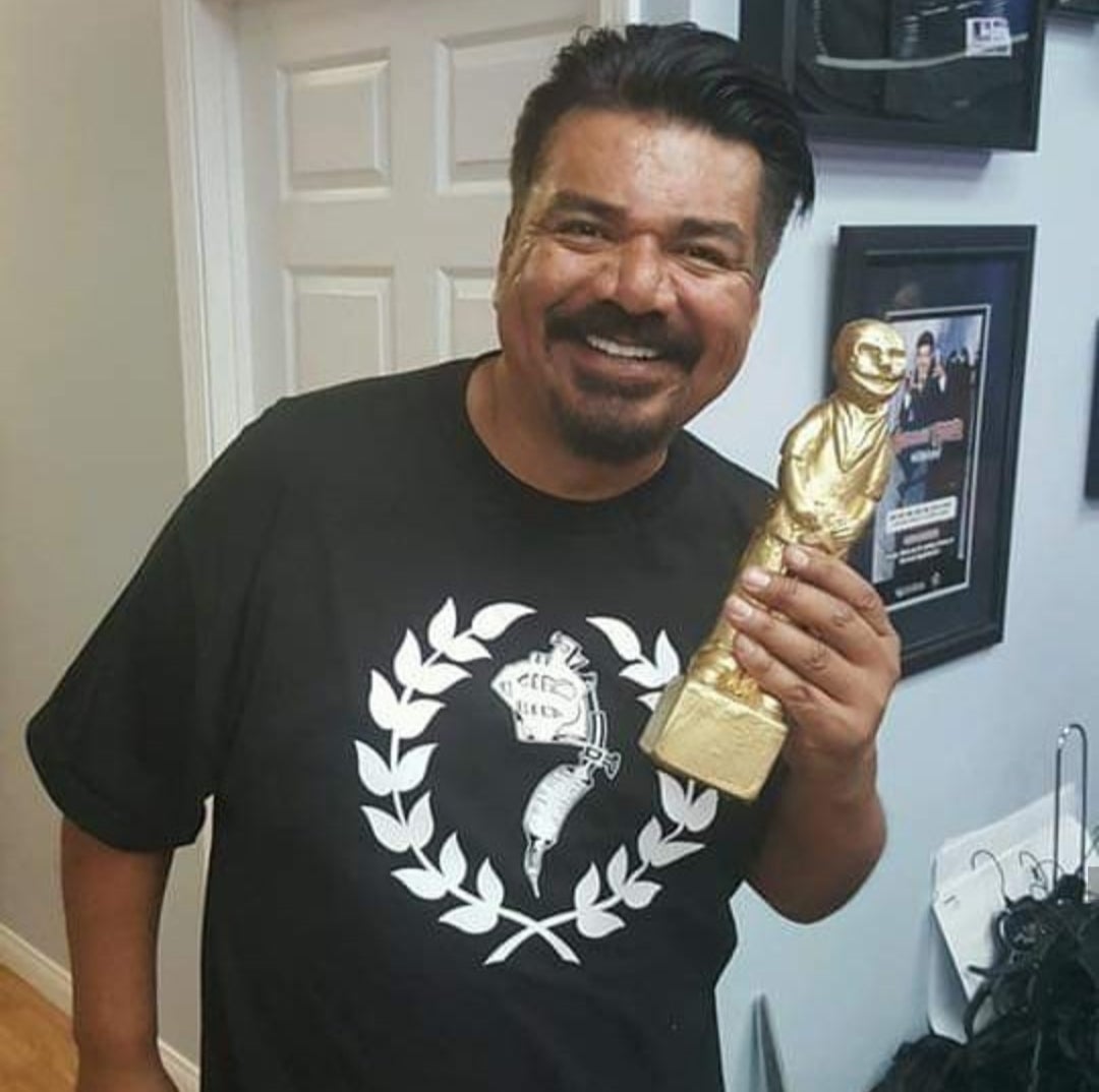 George Lopez holding a GRRRD award