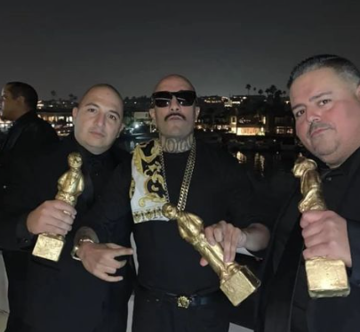Three honorees with their awards on the yacht at night