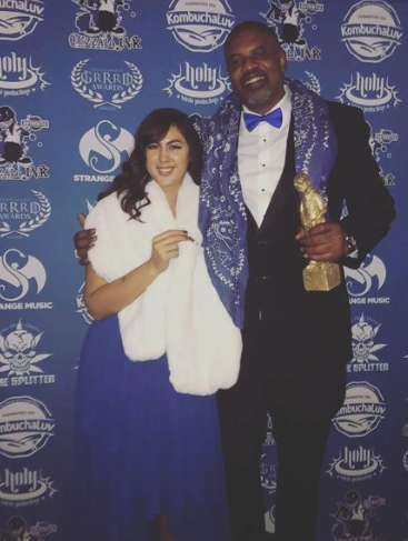 Honorees on the Blue Carpet holding a GRRRD award